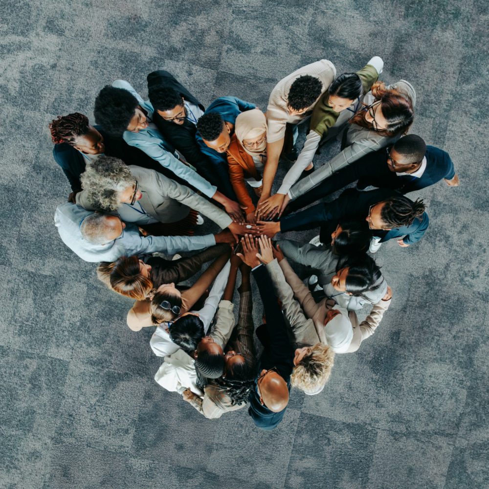 A diverse business group standing in a heart formation, symbolizing unity, teamwork, and collaboration.