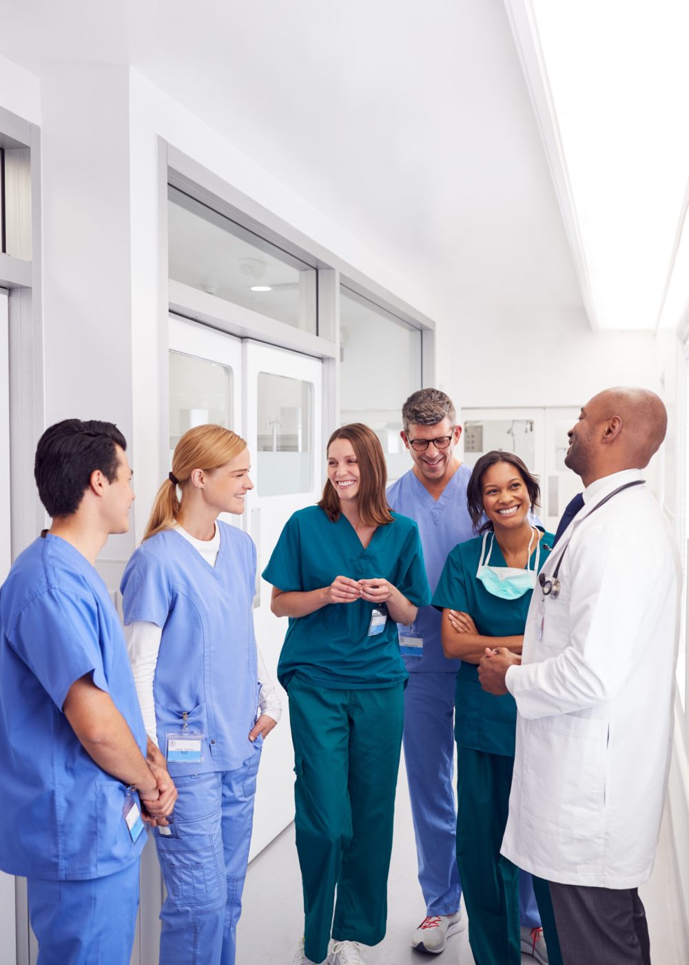 Multi-Cultural Medical Team Having Meeting In Hospital Corridor